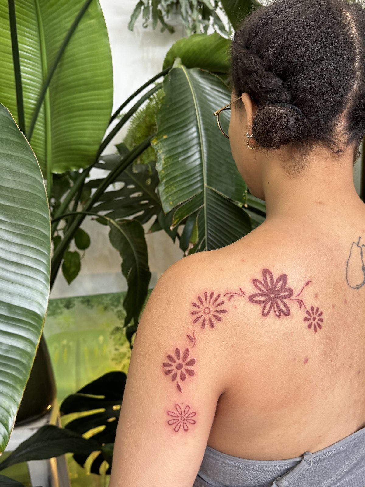 Bold illustrative floral shoulder tattoo in brown ink, by Gosia, Bristol